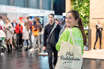 Junge Frau mit Stofftasche, die über die linke Schulter blickt